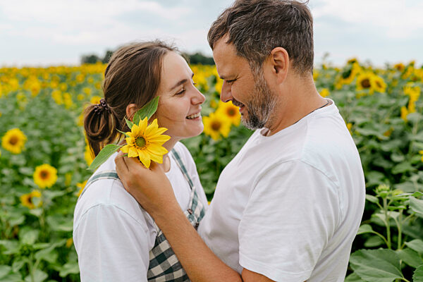 Couple embracing in sunflower field showing affection and joy