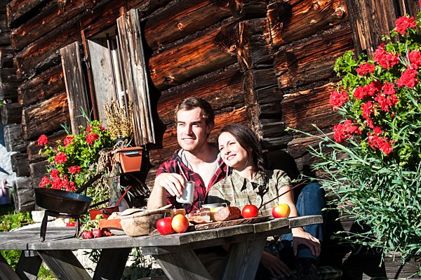 Austria, Altenmarkt-Zauchensee, couple having a break at alpine cabin