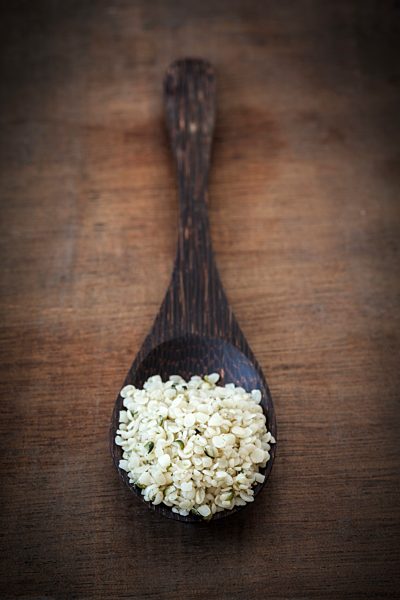 Peeled hamp seeds on wooden spoon