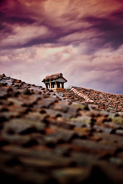 Italy, cloudy and stormy sky over ancient shingle roof