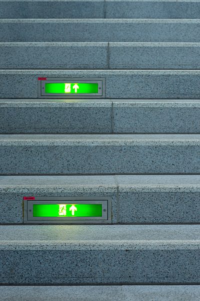 Public stairway with green emergency exit signs