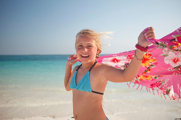 Tanzania, Zanzibar Island, portrait of girl with cloth at seafront