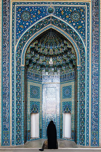 Iran, Yazd, woman wearing a chador praying at the Mihrab of Jameh Mosque