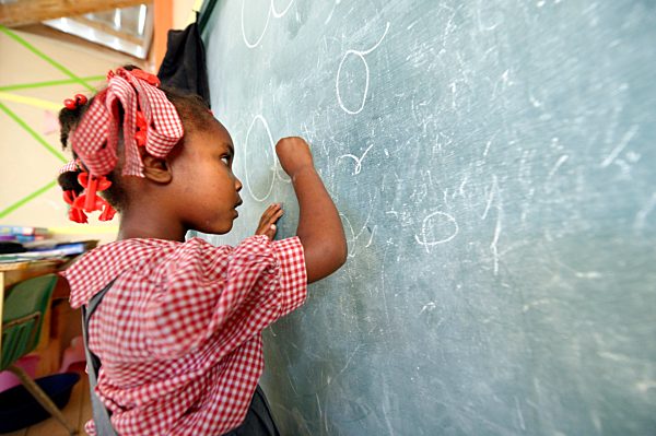 Haiti, Grand Boulage, schoolgirl writing on blackboard