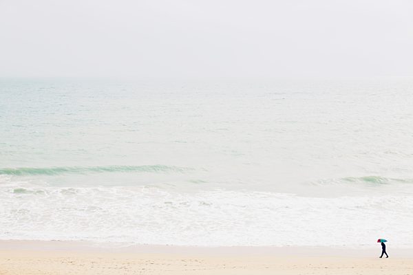 Spain, Mallorca, One person with umbrella walking along the beach