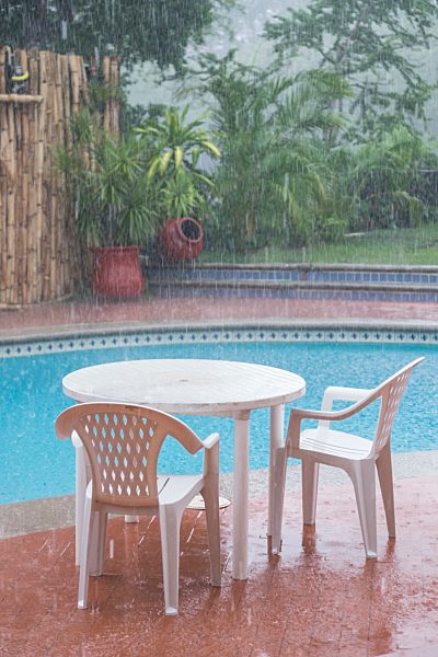 Mexico, Nayarit, heavy summer rain in residential backyard with swimming pool