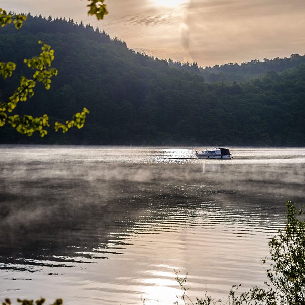 Germany, Hesse, Waldeck, Lake Edersee, boat and morning mist