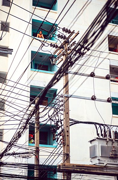 Thailand, Bangkok, tangled and messy electrical cables in front of multi-family house