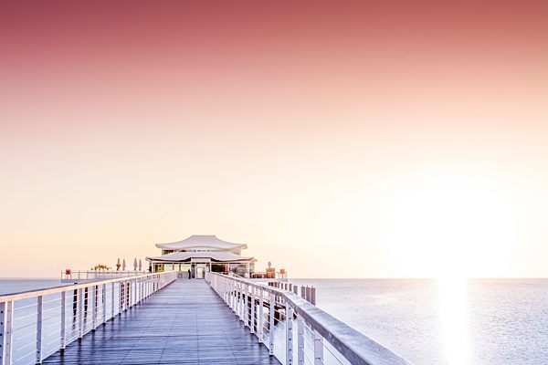 Germany, Niendorf, sea bridge with tea house at sunrise