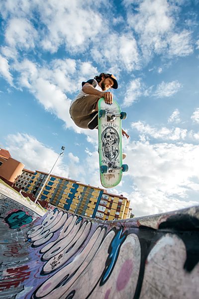 Young skateboarder jumping in the air in a skatepark