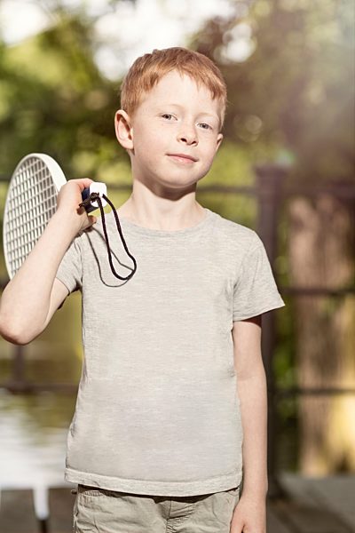 Portrait of little boy with tennis racket on his shoulder