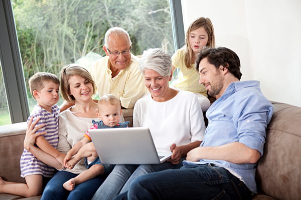 Extended family on couch using laptop