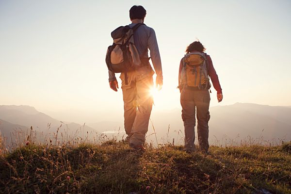 Austria, Tyrol, couple hiking at Unterberghorn at sunset