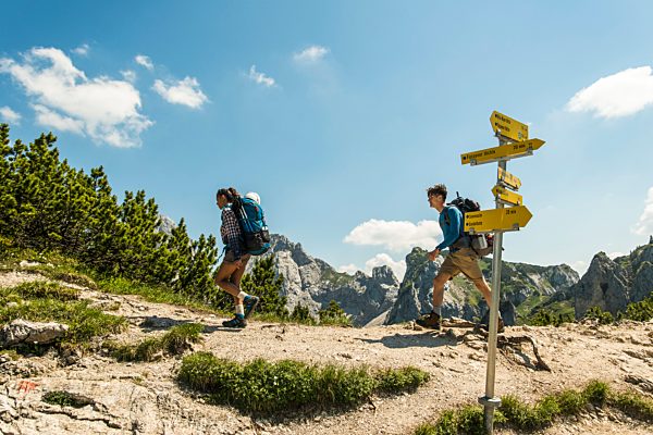 Austria, Tyrol, Tannheimer Tal, young couple hiking on mountain trail