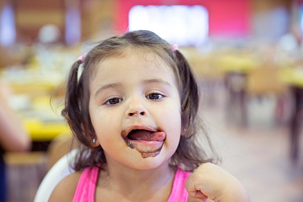 Portrait of little girl covered with ice cream