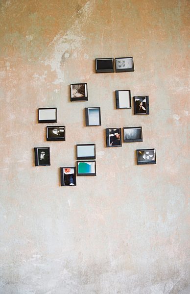 Instant photos in upcycled plastic boxes hanging on a wall