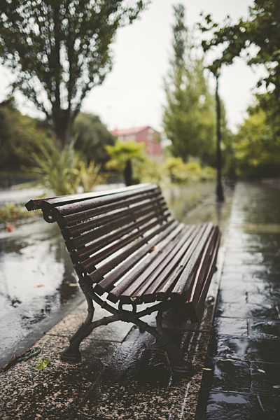 Spain, Galicia, Ferrol, Bench in a promenade, rain