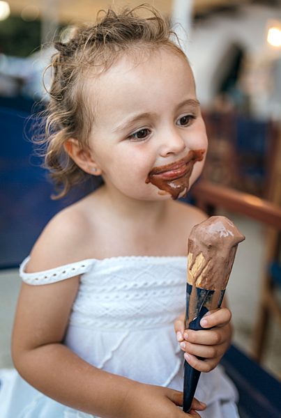 Portrait of smiling little girl with chocolate icecream around her mouth