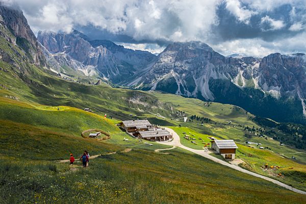 Italy, Dolomites, Odle mountain range, Hikers heading to a chalet