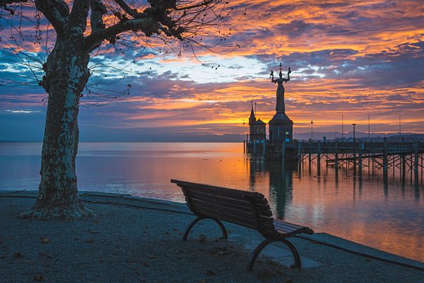 Germany, Constance,Bench facing the harbour entrance with Imperia statue