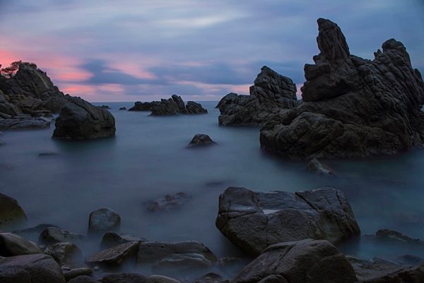 Spain, Costa Brava, Lloret de Mar, rock formations at Cala dels Frares by sunset
