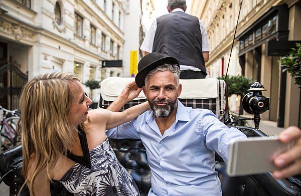 Austria, Vienna, couple having fun on sightseeing tour in a fiaker