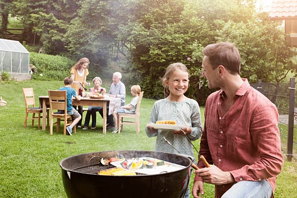 Smiling father and daughter on a family barbecue