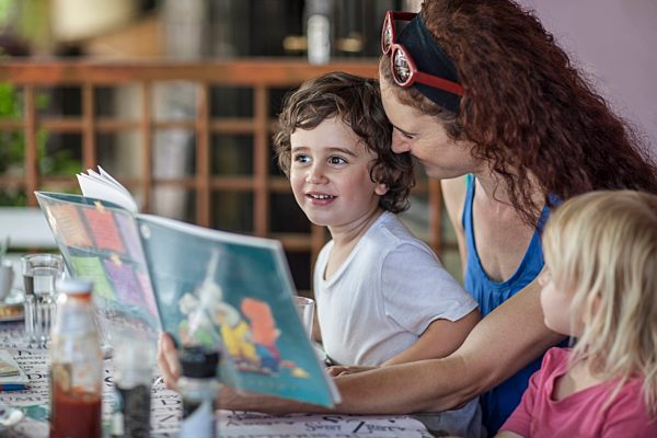 Mother reading book to kids