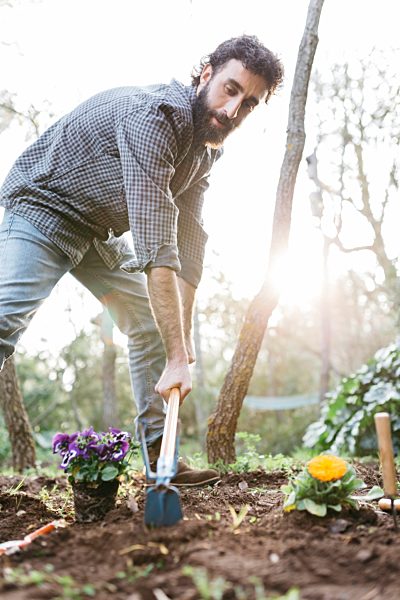 Man planting flowers in his garden