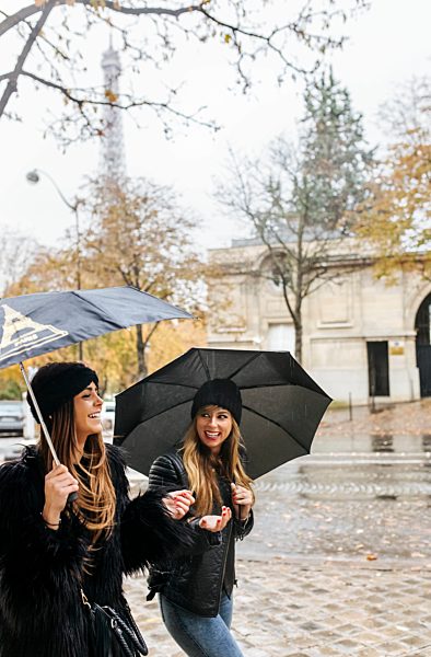 France, Paris, two young women walking in the city with the Eiffel Tower in the background