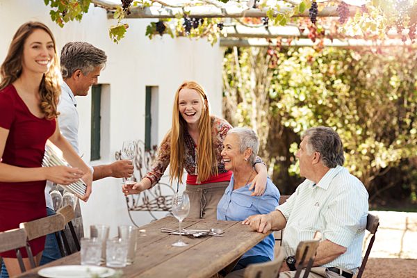 Happy family setting table outside for lunch