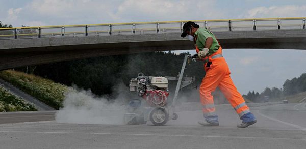 Ein Arbeiter säubert am Montag (30.06.2008) Dehnfugen an einer Betonfahrbahn...