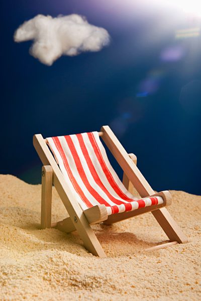 A miniature beach chair in sand