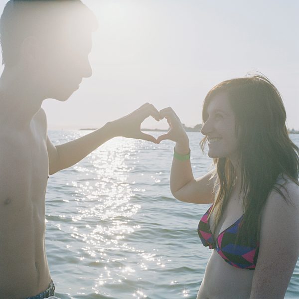 A young couple making a heart sign with their hands