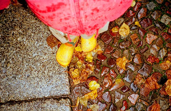 child's boots on wet cobblestone