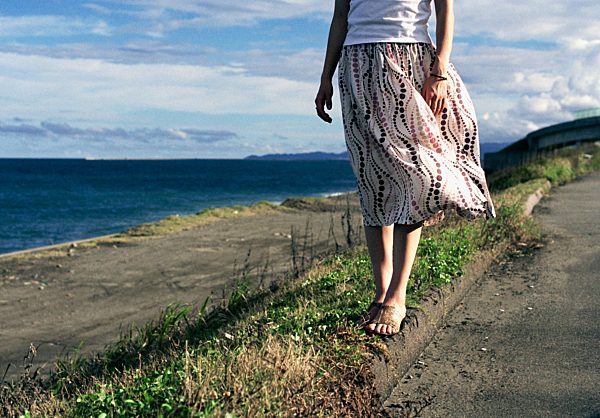 woman wearing a dress standing by the ocean