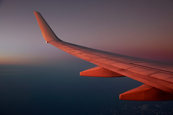 Jet above the clouds at dusk
