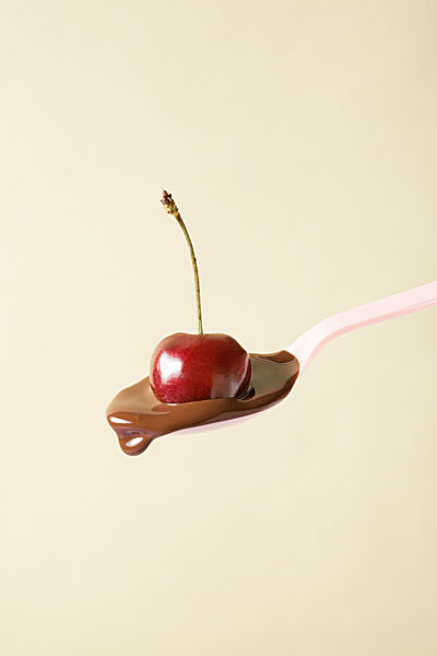 Cherry and melted chocolate on spoon