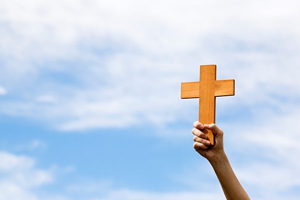 Person holding up a cross