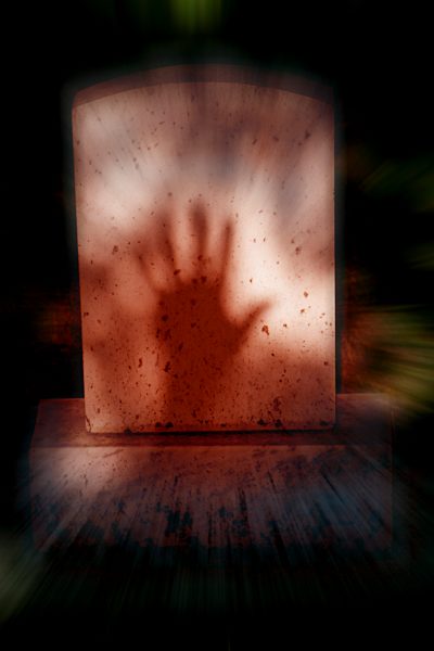Shadow of hand on tombstone