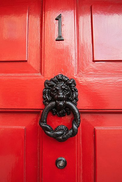Lion Door Knocker On A Red Shiny Door; Ireland