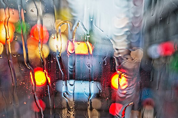 View Of A Car's Tail Lights Through A Wet Windshield; Amsterdam, Holland