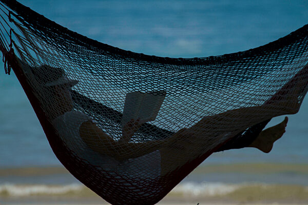Reading in a hammock on a beach