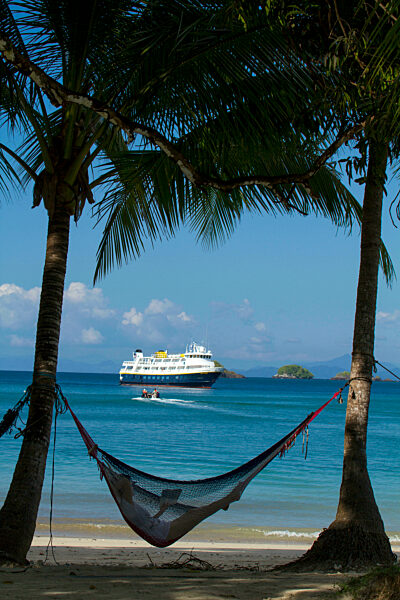 Tourist in a hammock overlooking the Pacific Ocean, Coiba National Park, Panama