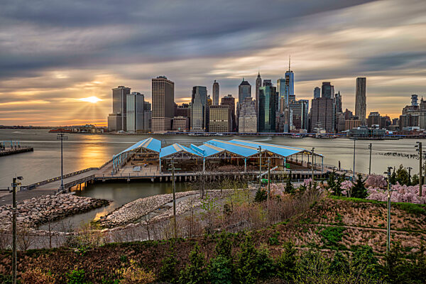 New York City skyline with sunset, view from Brooklyn Bridge Park over East River. New York City, NY, USA