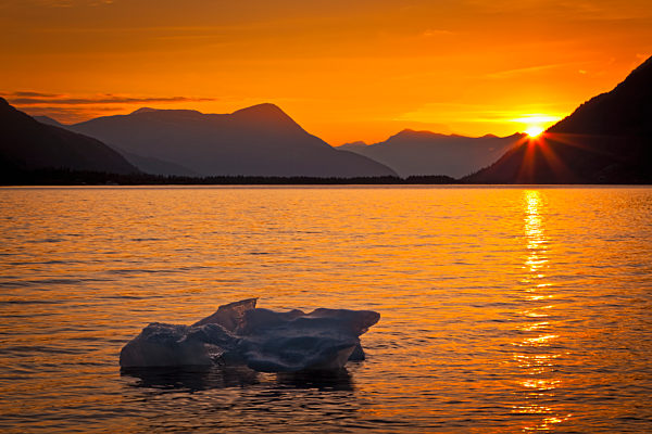 Iceberg Glows In Gold At Sunset, Portage Glacier, Kenai Peninsula; Alaska, United States Of America