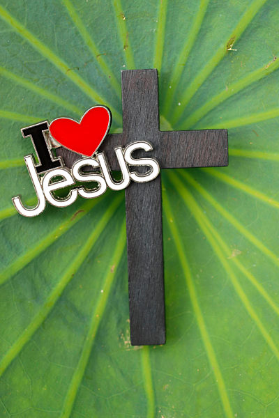 Christian cross and  love Jesus pin's on a green  lotus leave.
