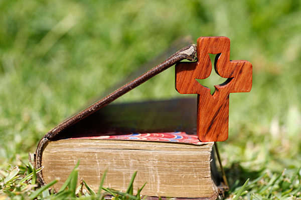 Cross of the order of the Holy Spirit on an open bible. Faith and spirituality.