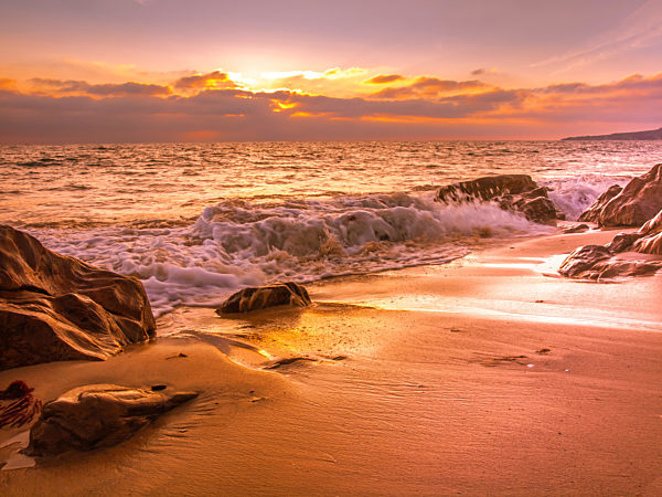 Sunset at a sandy beach with rocks in Tarifa, Spain, Costa de la luz