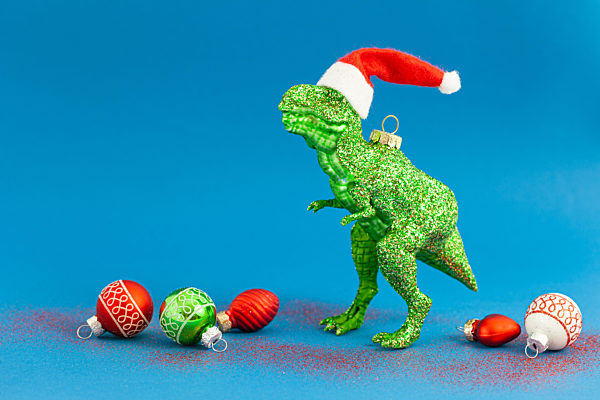 Kitschiger T-Rex mit Nikolaus Hut und Weihnachtskugeln zu Weihnachten